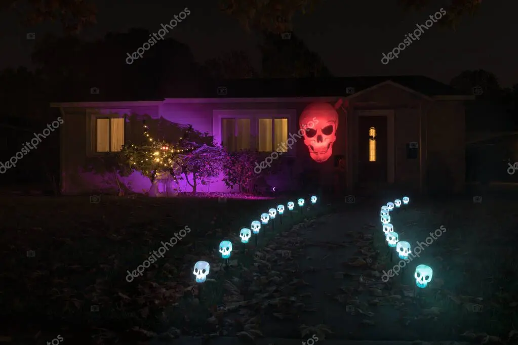 Front yard with pathway and wall-mounted outdoor lighting at night