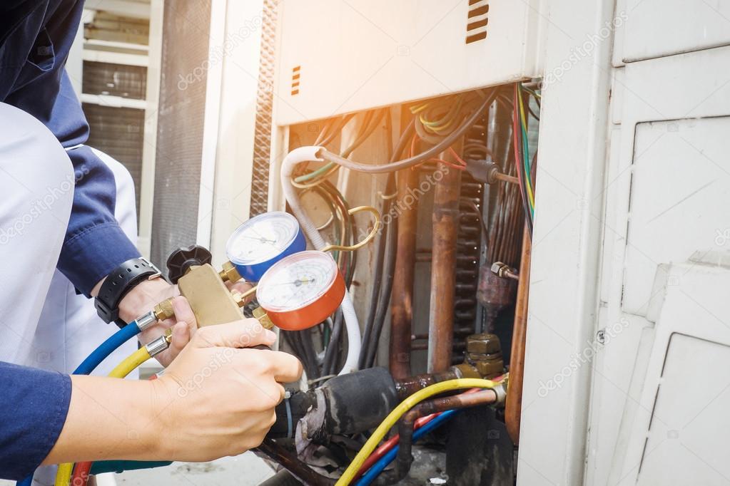 HVAC technician servicing an outdoor AC unit