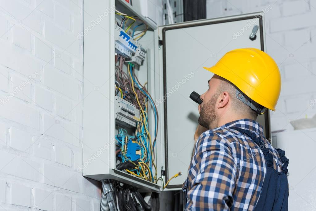 Electrician inspecting a residential electrical panel