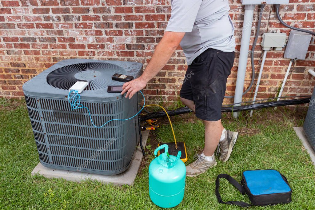 HVAC technician checking an AC condenser