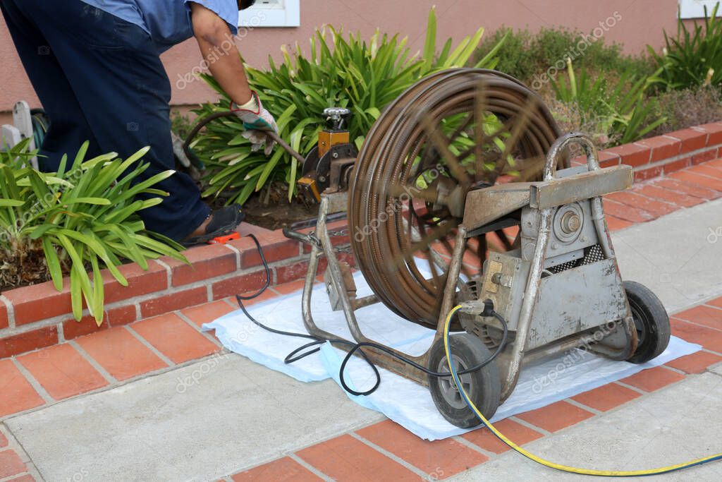 Drain cleaning machine clearing a clogged line