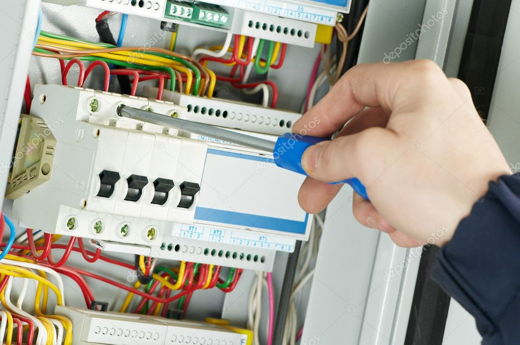 Electrician working inside a breaker panel