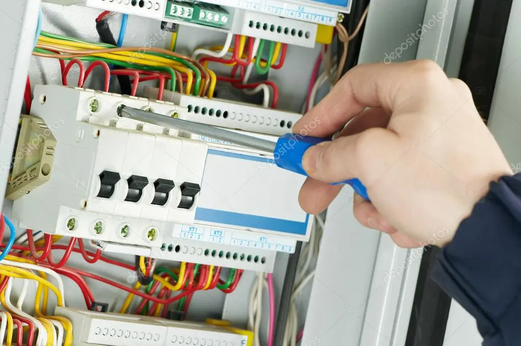 Electrician working inside a breaker panel