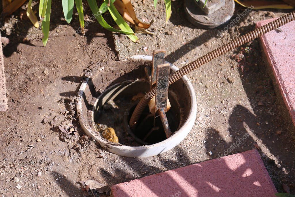Plumber feeding a sewer inspection camera into a drain