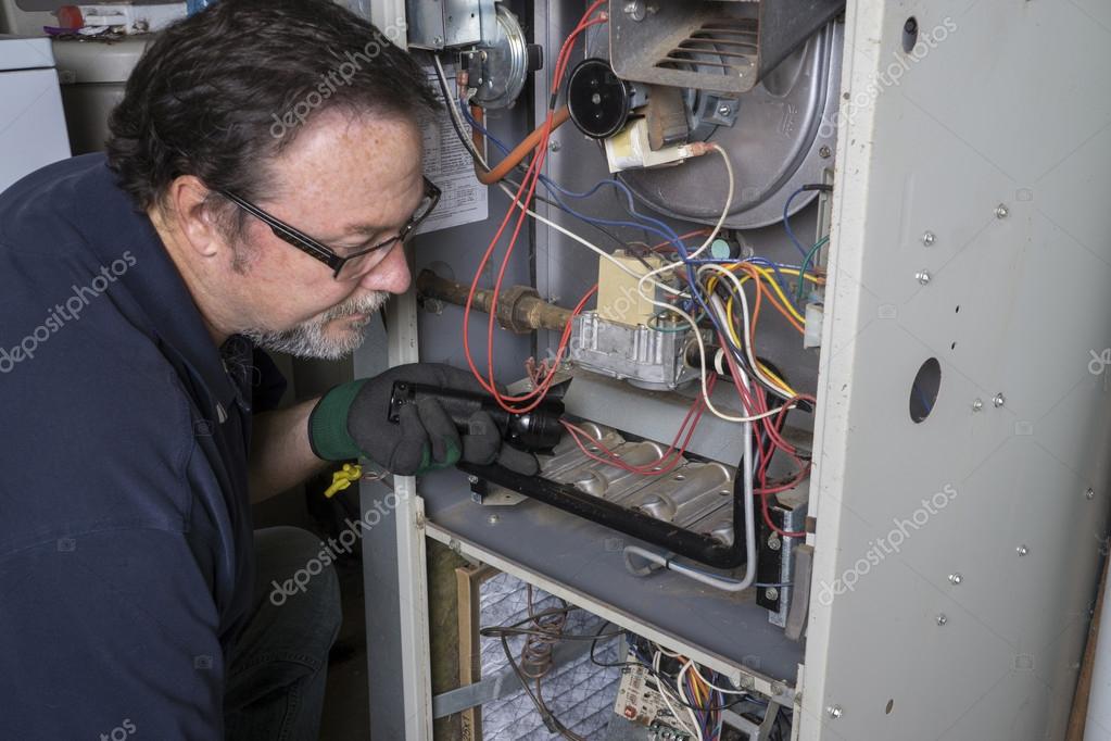 Technician repairing a residential furnace