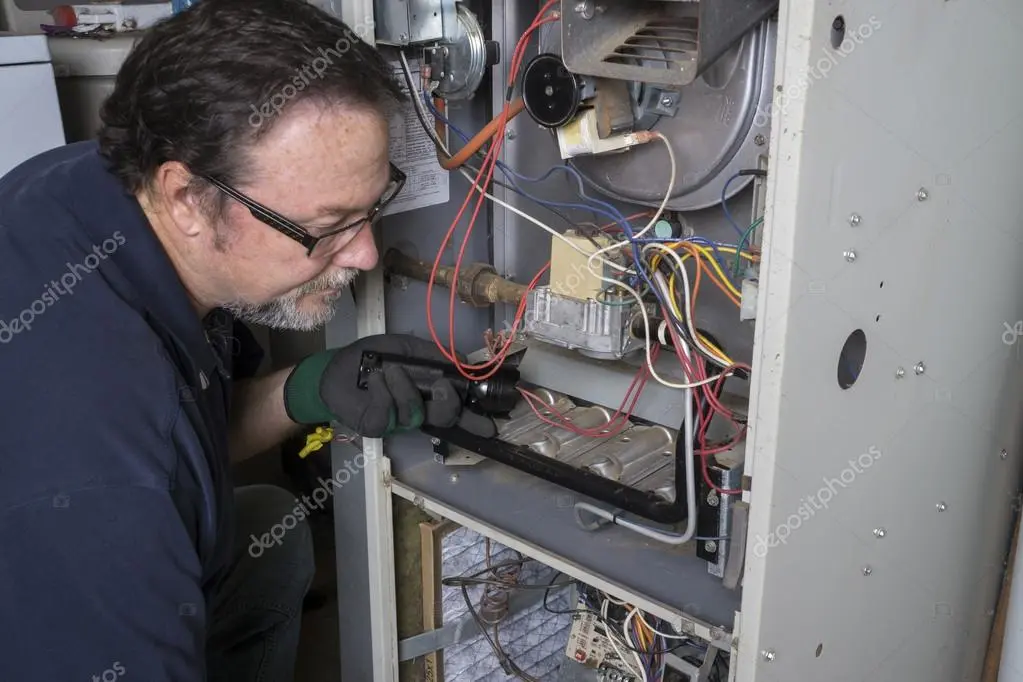 Technician repairing a residential furnace